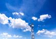 Shiny steel smokestack and cloud in blue sky