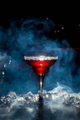 red cocktail with ice vapor, blue background