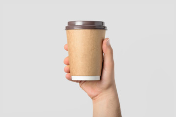 Wall Mural - Mockup of male hand holding a Coffee paper cup isolated on light grey background. 