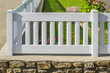 Gartenzaun aus Kunststoff in Weiß aus PVC auf einer Natursteinmauer - Plastic garden fence in white PVC on a natural stone wall