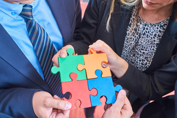 Group of business people assembling jigsaw puzzle