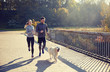 © Syda Productions - happy couple with dog running outdoors