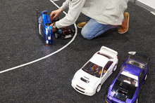 Man Repairs Radio-controlled Car On Race Track