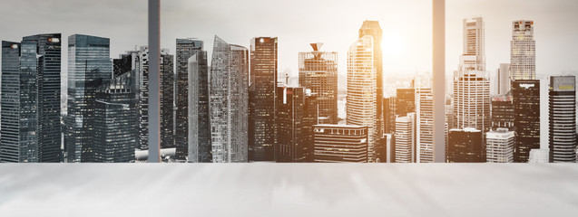 Poster - Desk with blurred panoramic view of Singapore downtown and skyline at sunset in office window.