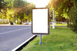 Blank white mock up of vertical light box in a bus stop in beautiful weather