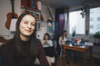 © Maskot - Portrait of happy young woman with female friend sittings in college dorm room