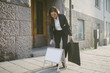 © Maskot - Mature female realtor standing by signboard on footpath against building in city