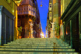 Fototapeta Uliczki - Narrow street stairs with corners of houses, decorated with statues of saints at night in the old town of Valletta, Malta