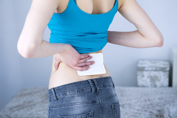 Woman applying heat patch