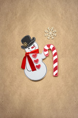 Wall Mural - Merry christmas / Creative photo of a snowman with a candy made of paper on brown background.