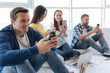 © Viacheslav Yakobchuk - Handsome cheerful man looking at the smartphone screen