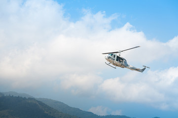 Helicopter in flight, blue sky background