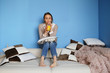 © Елена Кравчук - Young woman drinking orange juice while sitting on sofa, blue background