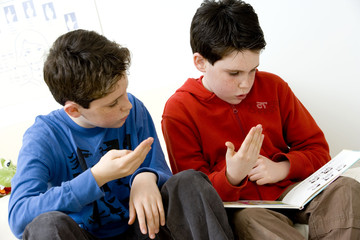 Models Do not use for HIV A young hearing-impaired boy and his brother using the French sign language with the aid of a book The French sign language uses signs to designate words but also dactylology (each letter of the alphabet is represented by a defined position of the fingers then enabling to spell a word) and the lip reading The young boys designate the word \need\