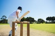 Side view of cricket player batting while playing on field