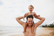 © Rob and Julia Campbell/Stocksy - Young dad having fun with toddler son on tropical beach - kid pulling hair