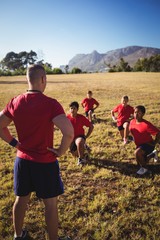 Wall Mural - trainer instructing kids while exercising in the boot camp