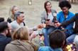 © Trinette Reed/Stocksy - Group of friends toasting red wine while sitting around fire pit