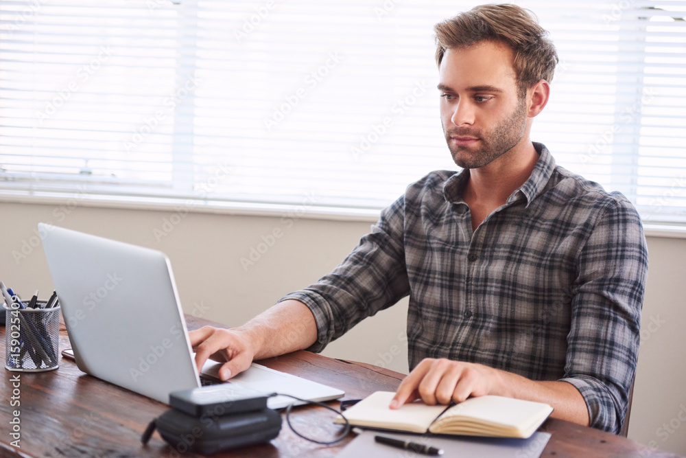 Young caucasian male writer busy digitalising his latest novel from ...
