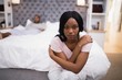 © WavebreakMediaMicro - Young woman sitting while man lying on bed at home