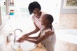 © WavebreakMediaMicro - Mother and daughter washing hands at sink in bathroom