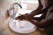 © WavebreakMediaMicro - Mid section of mother and daughter washing hands at sink