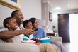 © WavebreakMediaMicro - Cheerful african american family having popcorn while watching television