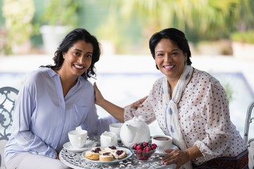 Portrait of woman having breakfast with mother