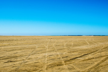 Wall Mural - very big sand space with a blue background sky