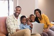 © WavebreakMediaMicro - Portrait of parents and children holding laptop