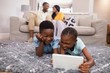 © WavebreakMediaMicro - Children using digital tablet while parents siting