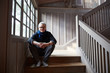 © Trinette Reed/Stocksy - Portrait of senior man while sitting on steps