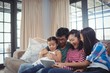© WavebreakMediaMicro - Smiling family using digital tablet together in living room