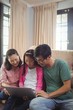 © WavebreakMediaMicro - Family using laptop together in living room