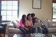 © WavebreakMediaMicro - Family using laptop together in living room