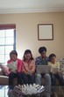 © WavebreakMediaMicro - Family using laptop, digital tablet and mobile phone in living room at home