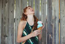 A Young Woman Eating A Waffle Cone With Cotton Candy In It