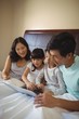 © wavebreak3 - Family using laptop together in bedroom