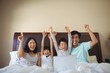 © wavebreak3 - Family using laptop together in bedroom