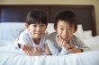 © wavebreak3 - Siblings relaxing on bed in bedroom