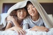 © wavebreak3 - Siblings relaxing under blanket in bedroom