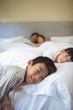 © wavebreak3 - Siblings sleeping on bed in bedroom