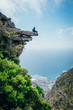 © Micky Wiswedel/Stocksy - Hiker on an exposed mountain ledge overlooking the sea