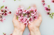 © Javier Pardina/Stocksy - pink flowers in the hands