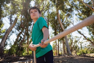 Wall Mural - boy practicing tug of war during obstacle course training