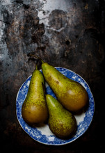 Three Conference Pears On Blue Plate,against Metal Background