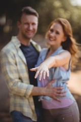 Wall Mural - Smiling woman showing ring with man at olive farm