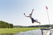© Raymond Forbes LLC/Stocksy - Teen Jumping off Dock to Catch a Football