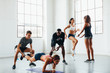 © BONNINSTUDIO/Stocksy - Young multiethnic teamwork doing exercises at indoors bootcamp