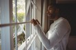 © WavebreakMediaMicro - Thoughtful man looking out through window at home